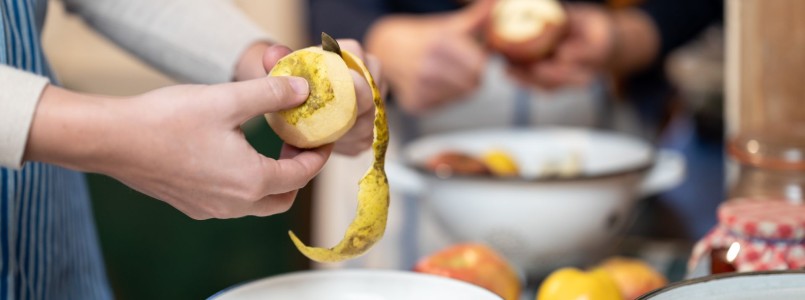 Detail von Händen die Äpfel mit einem Messer schälen