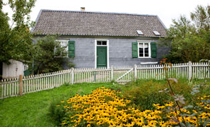 Das Bandweberhaus der Familie Thiemann: Blick über den blühenden Garten zur Eingangstür in der verschieferten Fassade