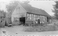 Schwarz-Weißaufnahme: Die Schmiede an ihrem Originalstandort in Lindlar-Linde, 1930er Jahre