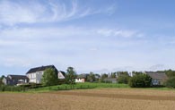 Ein Blick über den gepflügten Acker auf die Baugruppe Oberlingenbach mit der historischen Gaststätte Römer und der Scheune Denklingen