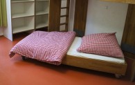 Ein Pflegebett, das auf Rollen gelagert ist, ist unter einem Etagenbett hervor gezogen